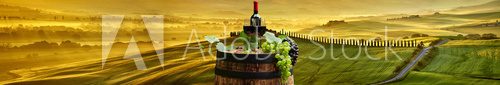 Fototapeta Red wine bottle and wine glass on wodden barrel. Beautiful Tusca