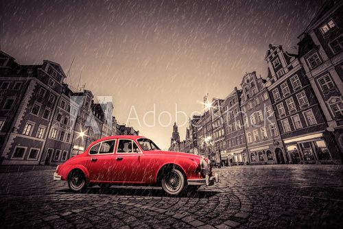 Fototapeta Retro red car on cobblestone historic old town in rain. Wroclaw, Poland.