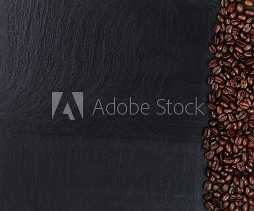Fototapeta Roasted coffee beans on natural dark slate stone