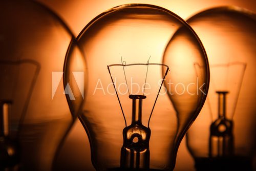 Fototapeta Row of light bulbs on a bright amber background