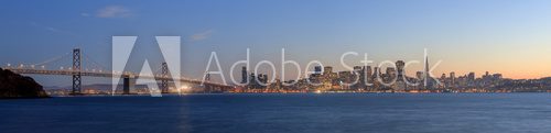 Fototapeta San Francisco â Oakland Bay Bridge with lights at sunset time