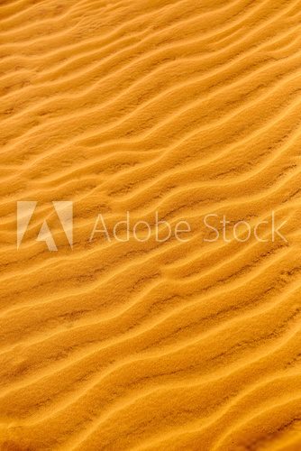 Fototapeta Sand Texture Background. Close up view of orange ripple sand pattern of dunes in desert. Nature elements details. 