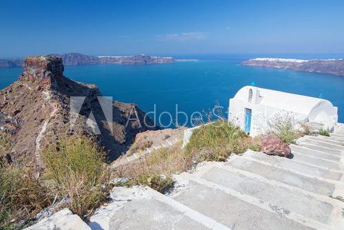 Fototapeta Santorini - The look to typically little church in Imerovigli and the Skaros castle.
