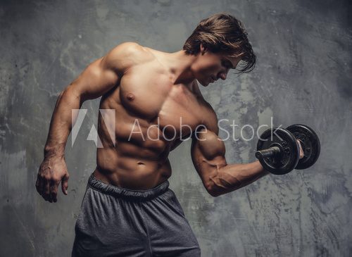 Fototapeta Shirtless muscular man doing biceps workout.