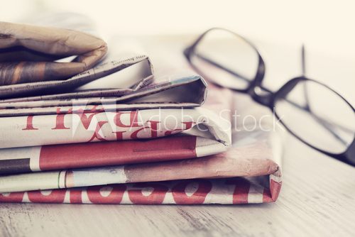 Fototapeta Stack of newspapers and eyeglasses