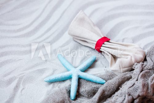 Fototapeta starfish, pouch and fishnet on the sand