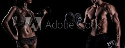 Fototapeta strong young couple working out with dumbbells. Shot in studio o