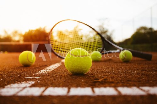 Fototapeta Tennis balls with racket on clay court