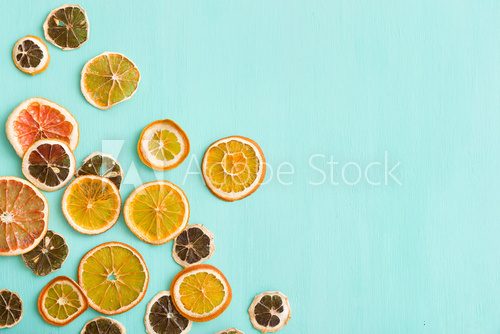 Fototapeta Top view on handmade citrus chips: orange, lemon, grapefruit on turquoise wooden background.