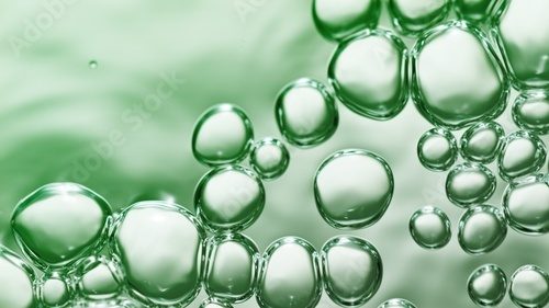 Fototapeta transparent gas bubbles on water surface. Worms-eye low angle with crystal bubbles in purified water on green background. cosmetic backdrop with copy space