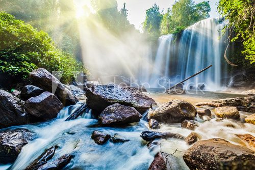 Fototapeta Tropical waterfall in jungle with sun rays