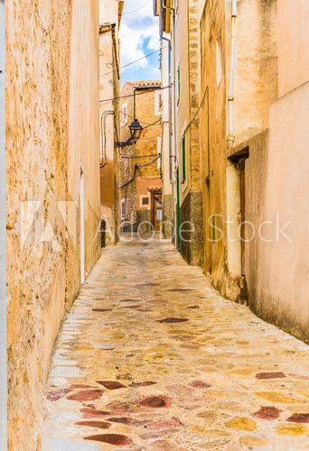 Fototapeta View of a old rustic alleyway with old paving stones and mediterranean buildings