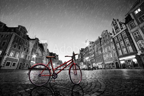 Fototapeta Vintage red bike on cobblestone historic old town in rain. Wroclaw, Poland.