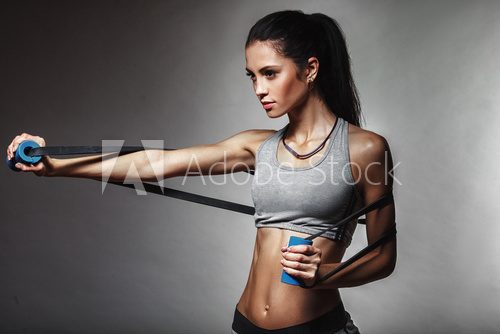 Fototapeta woman exercising with rubber tape