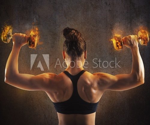 Fototapeta Woman training with  fiery dumbbells