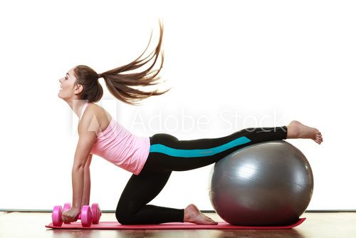 Fototapeta woman with gym ball and dumb bells isolated