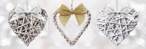 Fototapeta Wooden Hearts braided with ribbon bow isolated on silver blurred